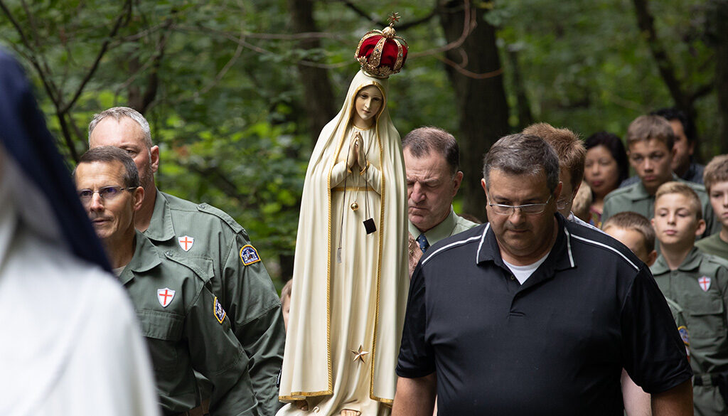 The weeping statue of Our Lady of Fatima being carried by a small group of men during the procession of Saint George.