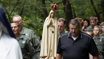 The weeping statue of Our Lady of Fatima being carried by a small group of men during the procession of Saint George.