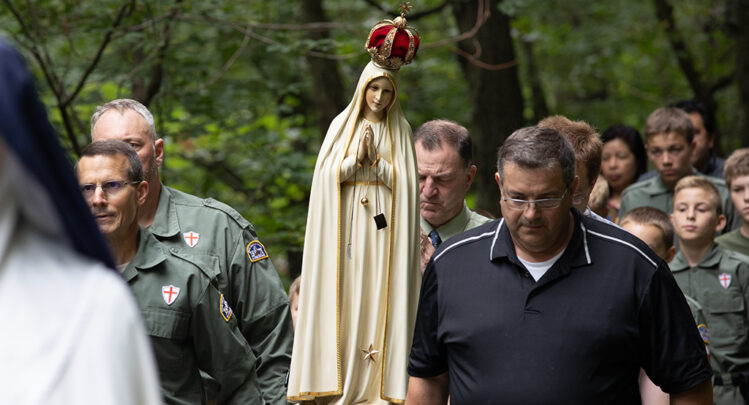 The weeping statue of Our Lady of Fatima being carried by a small group of men during the procession of Saint George.