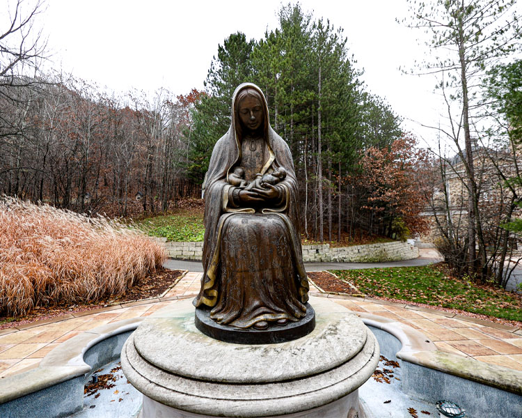 Statue of Lady Guadalupe in front of the Memorial to the Unborn holding three babies at Our Lady of Guadalupe Shrine in La Crosse, Wisconsin.