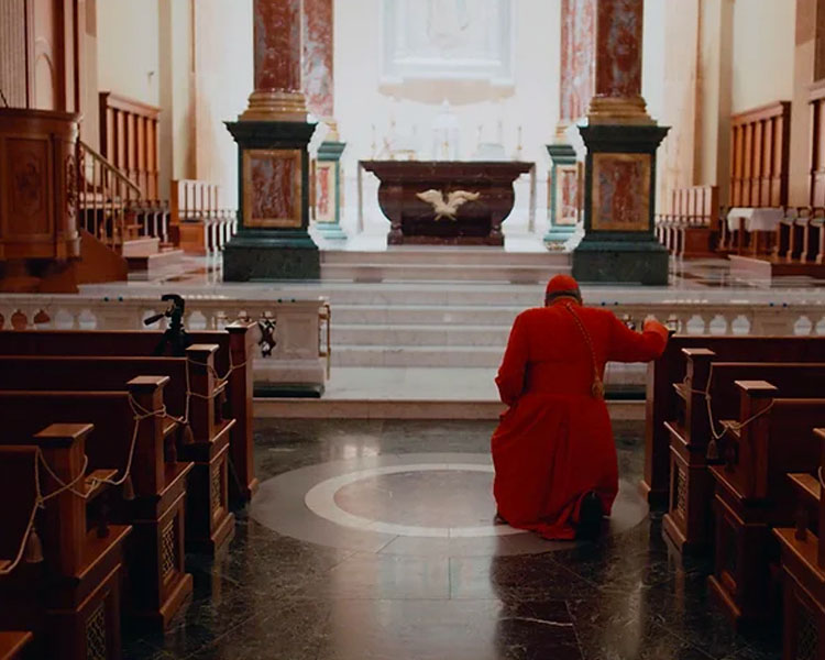 Cardinal Leo Burke kneeling at the altar at Our Lady of Guadalupe Shrine in La Crosse, Wisconsin.