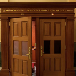 Door leading to the confessional with Latin wording above reading "Quorum Remiseritis Peccata Remissa Sunt Eis" at Our Lady of Guadalupe Shrine in La Crosse, Wisconsin.