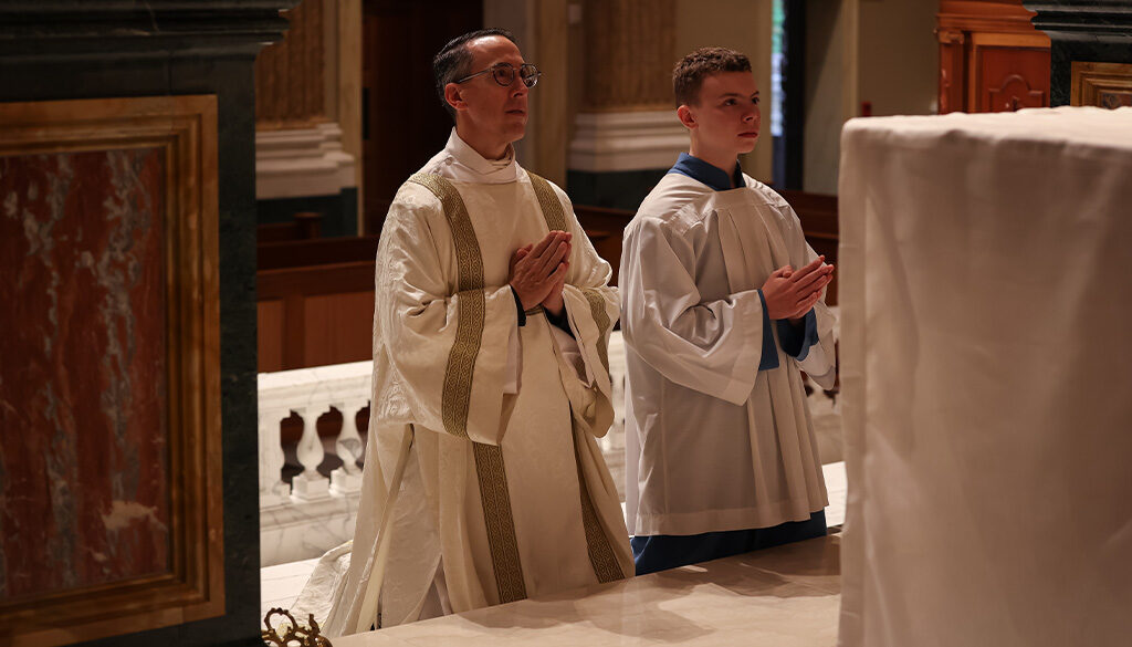 Deacon Kabat and his Altar Server son kneeled before the altar focused in prayer.