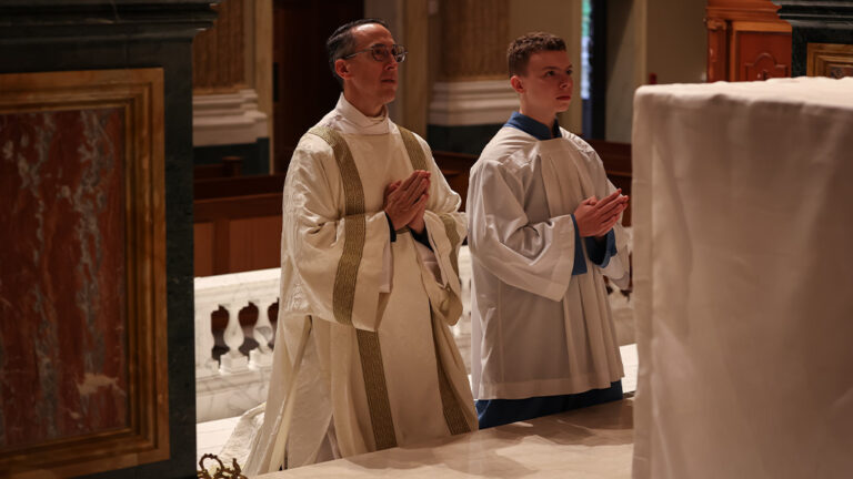 Deacon Kabat and his Altar Server son kneeled before the altar focused in prayer.