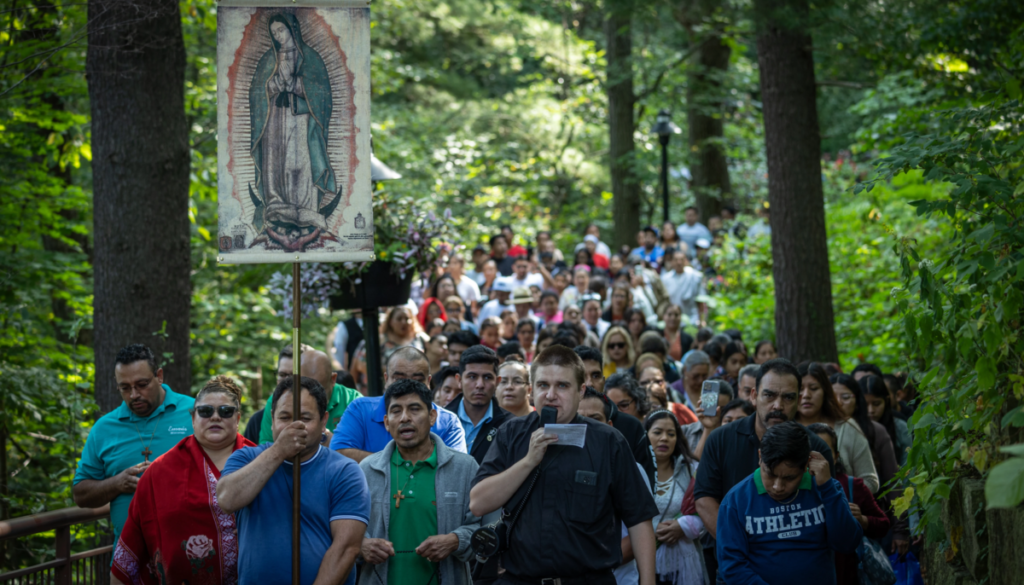 A man carrying an image of Lady Guadalupe leads hundreds of people through the pathway of Our Lady of Guadalupe Shrine for Our Lady's Nativity in La Crosse, Wisconsin.