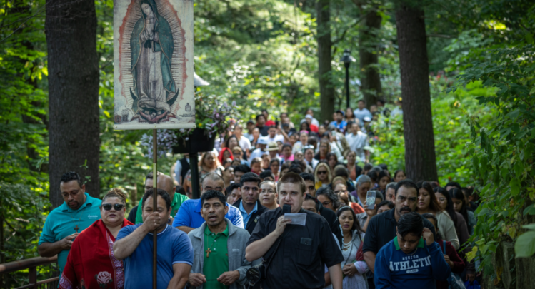 A man carrying an image of Lady Guadalupe leads hundreds of people through the pathway of Our Lady of Guadalupe Shrine for Our Lady's Nativity in La Crosse, Wisconsin.