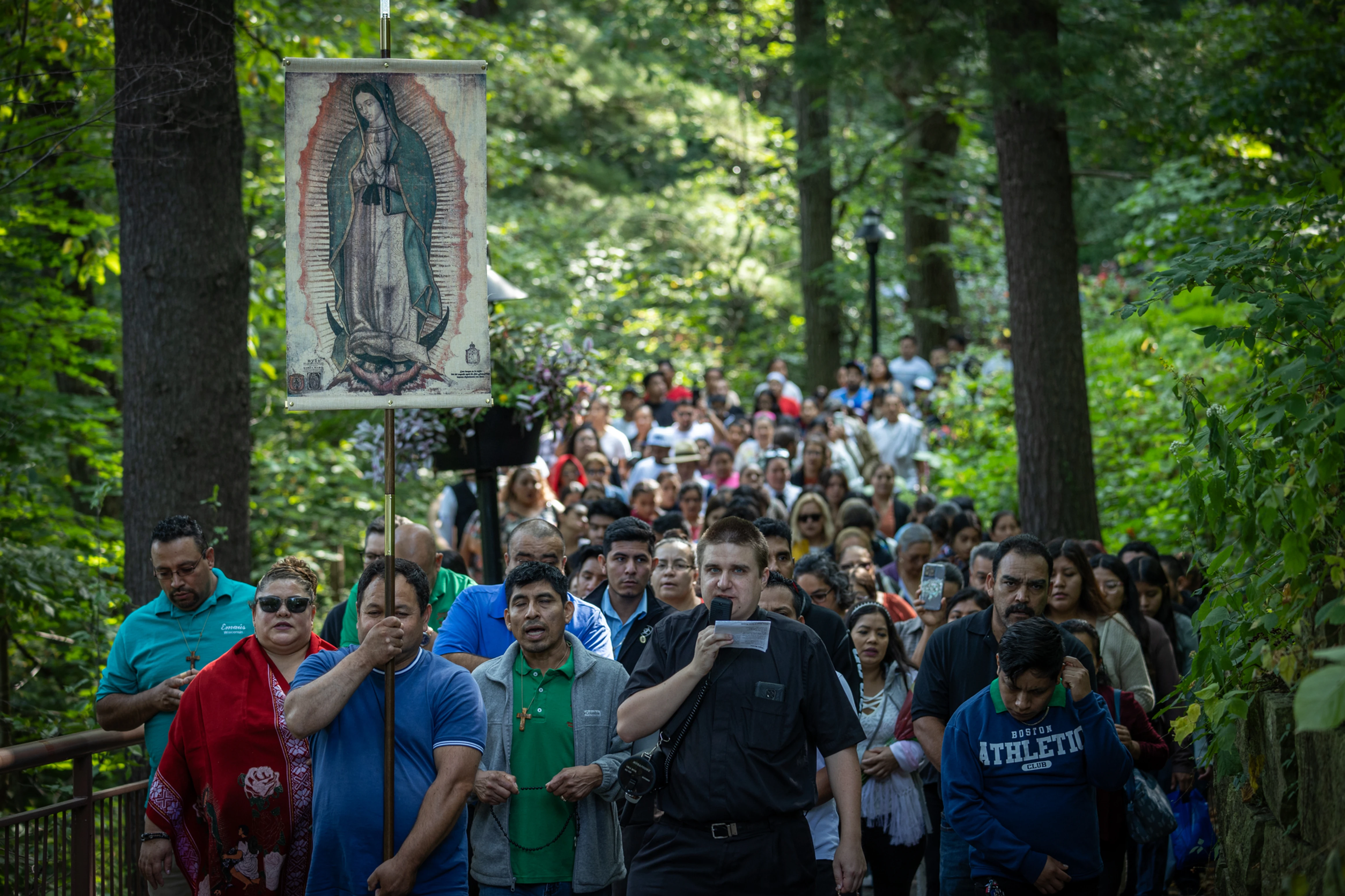 A man carrying an image of Lady Guadalupe leads hundreds of people through the pathway of Our Lady of Guadalupe Shrine for Our Lady's Nativity in La Crosse, Wisconsin.
