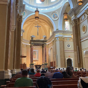 Congregation members sitting in pews during mass at Our Lady of Guadalupe Shrine in La Crosse, Wisconsin.