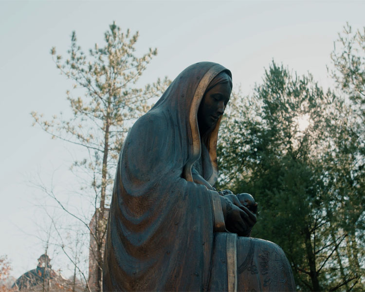 Side angle of the statue of Lady Guadalupe holding three babies at the Memorial to the Unborn at Our Lady of Guadalupe Shrine in La Crosse, Wisconsin.