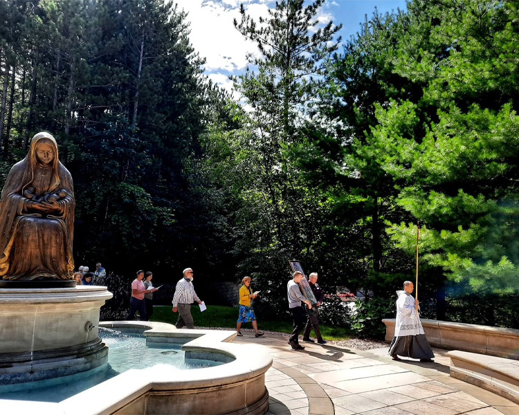 Father Check leading a group of people on a pilgrimage through the Memorial to the Unborn at Our Lady of Guadalupe Shrine in La Crosse, Wisconsin.