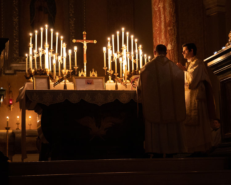 Father Paul Check praying with a Priest during Pontifical High Mass at Our Lady of Guadalupe Shrine in La Crosse, Wisconsin.