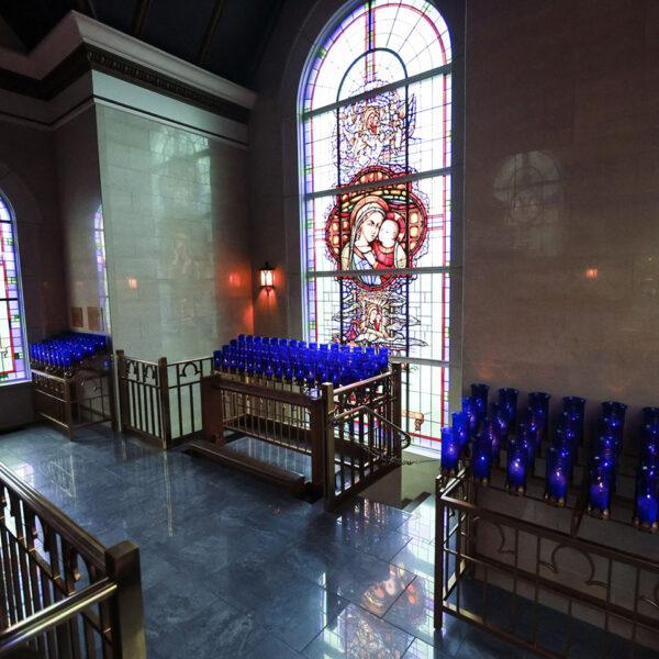 Stained glass windows and lit up candles in the Votive Candle Chapel at Our Lady of Guadalupe Shrine in La Crosse, Wisconsin.