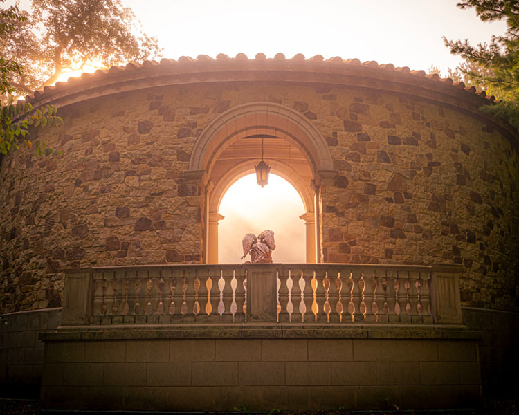 Sun setting over the balcony of the Memorial to the Unborn. A statue of two angels sit under the archway at The Shrine of Our Lady of Guadalupe in La Crosse, Wisconsin.