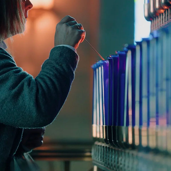 A woman lighting a candle in the Votive Chapel of Our Lady of Guadalupe Shrine in La Crosse, Wisconsin.