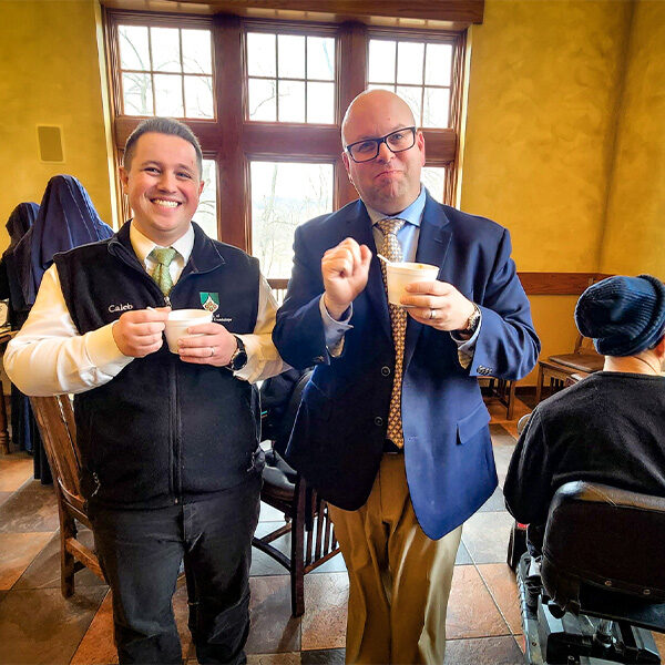 Caleb and Ed standing next to each other with a cup of chili posing for the picture.