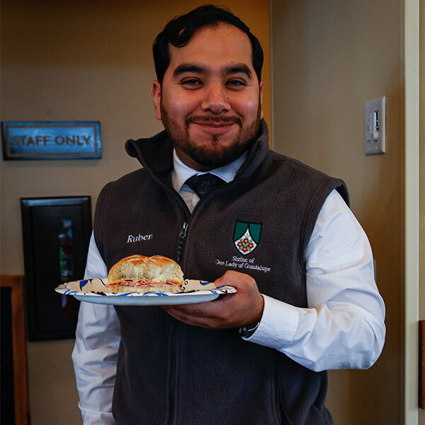 Ruben stands joyfully while holding his plate with a ham sandwich from the Shrine during the chili cookoff.