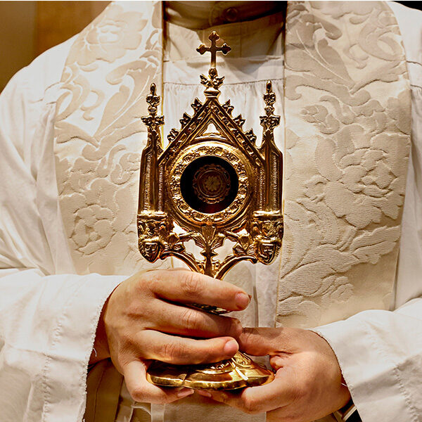 A closeup of a priest holding a blessed reliquary relic.