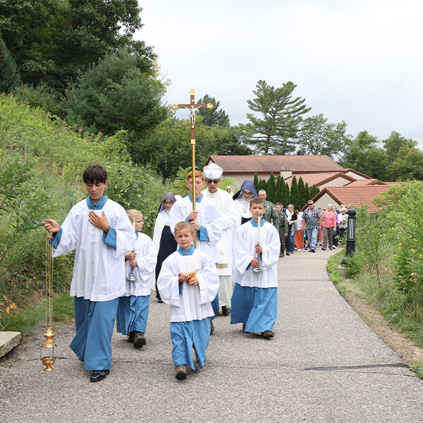 A group of altar server boys and a Norbertine Priest walk the uphill procession for the devotion of Our Lady of Fatima.