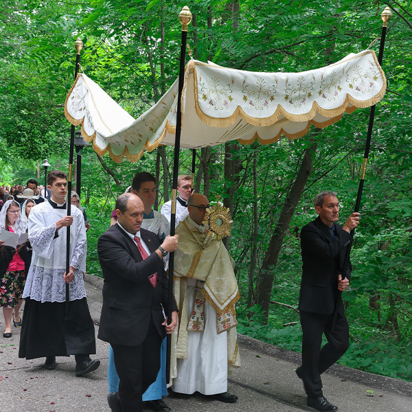 A group of men and women walking the Shrine path during the Corpus Christi Procession Eucharist.