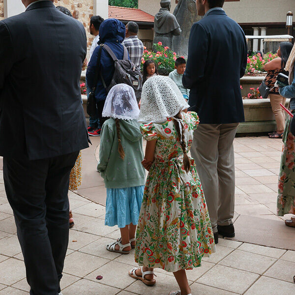 During the Sunday procession, two young girls wear their veils in protection.