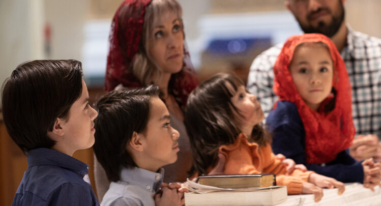 An up close image of the pilgrimage family kneeling in front of the Shrine's altar.