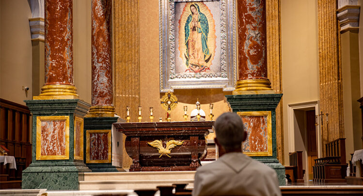 what is a pilgrimage - norbertine praying in church with eucharistic adoration with tilma of mary in background