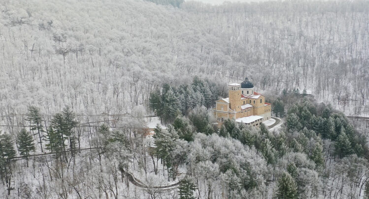 An aerial view of the Shrine of Our Lady of Guadalupe surrounded by bluffs and trees covered in snow during winter in La Crosse, Wisconsin.