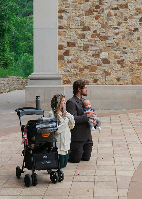 Father kneeling with son and wife for Eucharistic Procession