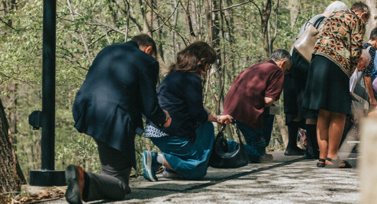 Pilgrims Genuflecting or kneeling at the outdoor stations of the cross