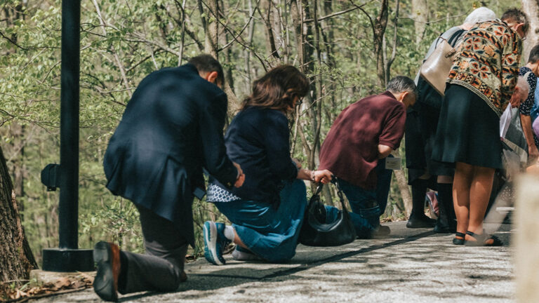 Pilgrims Genuflecting or kneeling at the outdoor stations of the cross