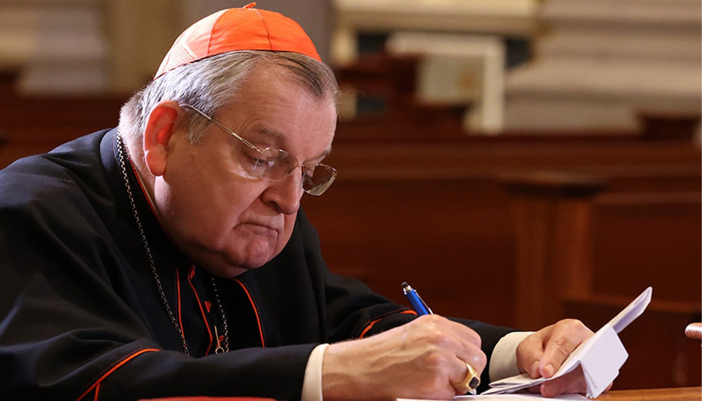 Cardinal Burke writing in the Shrine Church