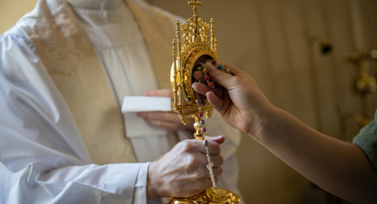 Rosary touching a saint's relic, creating a third class relic