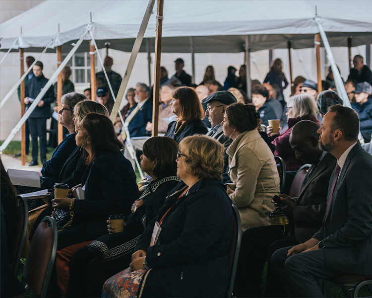 People gathered under the tent for the Pilgrim House ground breaking