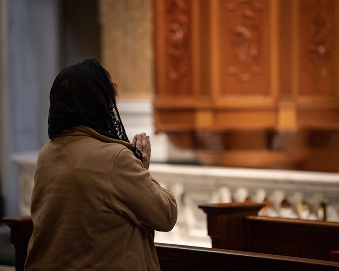 Pilgrim praying in the Shrine Church with black veil