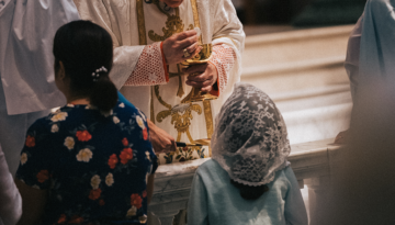 Young Catholic receiving communion at the communion rail