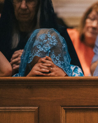 Young lady praying in Guadalupe Shrine pews