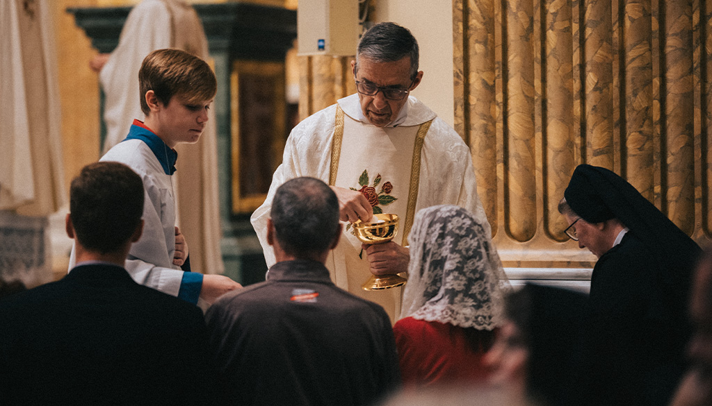 Father Hildebrand distributing Holy Communion at the Communion Rail