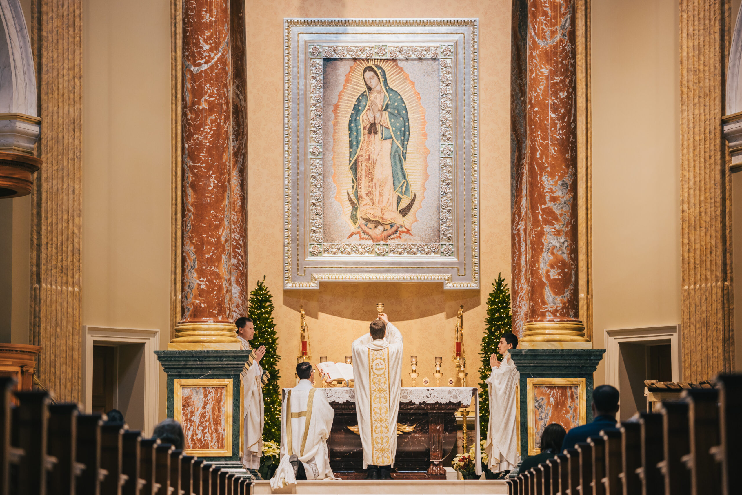 Bishop Vitalii Kryvytskyi elevating the Precious Blood of Christ in front of a mosaic of Our Lady of Guadalupe