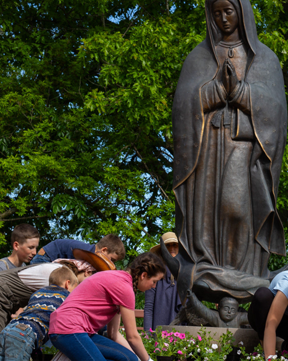 our lady of guadalupe statue at the guadalupe shrine being planted with flowers in the spring